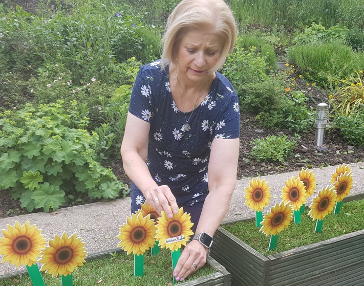 Mary Pomfret - Planting a sunflower in memory of her husband